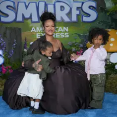Rihanna z dziećmi na tle Smerfów. Mama tuli jedno dziecko, drugie stoi obok.
