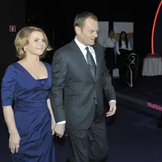 Małgorzata Tusk, żona Michała Tuska, w niebieskiej sukni, idzie z mężem.