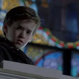 Chłopiec z filmu "Szósty zmysł" wpatruje się w witraż, jakby widział coś więcej.